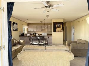 a living room with two couches and a kitchen at 8 Coral Haven in Christ Church