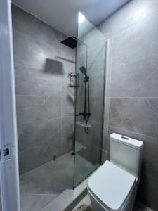 a bathroom with a toilet and a glass shower at Sylz Residence Studio in Accra