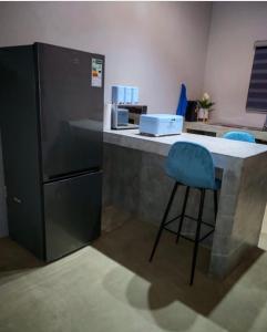 een keuken met een aanrecht met een blauwe barkruk bij Neotha Villa Unit 2 in Marloth Park