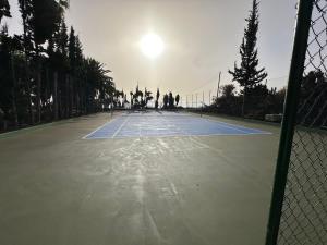a tennis court with the sun shining on it at Almabella in Breña Baja