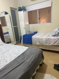 a hotel room with two beds and a mirror at A casa do Breno in São José da Coroa Grande