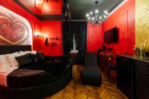 a bedroom with red walls and a bed and a desk at Love Krak-Off - BDSM Old Town in Krakow