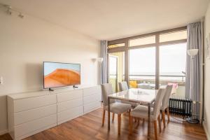 ein Wohnzimmer mit Esstisch und Fernseher in der Unterkunft Immerschön in Schilksee