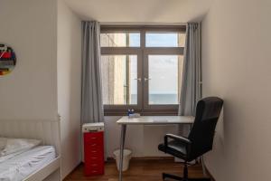 ein Schlafzimmer mit einem Schreibtisch, einem Fenster und einem Stuhl in der Unterkunft Immerschön in Schilksee
