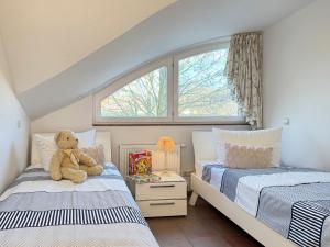 a teddy bear sitting on top of two beds in a bedroom at Ruheoase in Prerow
