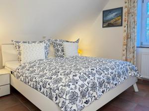 a bedroom with a bed with a black and white comforter at Ruheoase in Prerow +16 photos