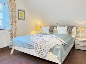 a bedroom with a white bed with blue sheets and pillows at Ruheoase in Prerow