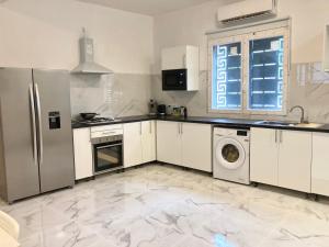 eine Küche mit Kühlschrank und Waschmaschine in der Unterkunft Villa Côte d Azur - 4 chambres, 4 TV, 4 salles de bain privatives - Internet Netflix in Mtsamboro