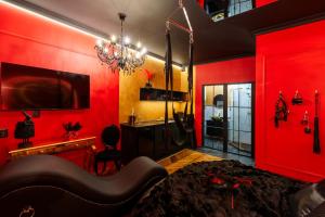 a red room with a bed and a chandelier at Love Krak-Off - BDSM Old Town in Krakow