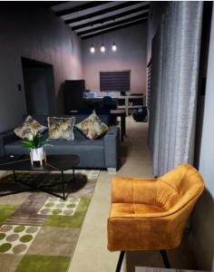 een woonkamer met een bank en een tafel bij Neotha Villa Unit 2 in Marloth Park +8 foto's