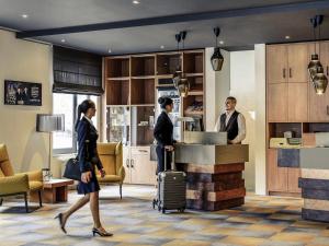 een groep mensen die rond een balie met bagage staan bij Mercure Hotel Mannheim am Rathaus in Mannheim
