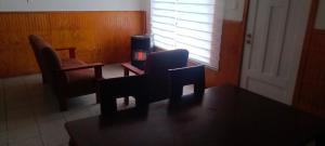 een kamer met 2 stoelen, een tafel en een tv bij Cabañas Centrales in Valdivia