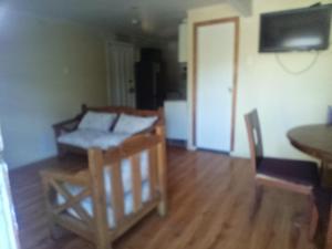 een woonkamer met een bank, een tafel en stoelen bij Cabañas Centrales in Valdivia