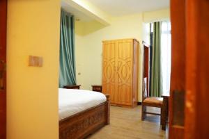 a bedroom with a bed and a wooden cabinet at Kings Land Hotel in Lalībela