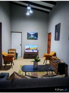 een woonkamer met een bank en een tv bij Neotha Villa Unit 2 in Marloth Park