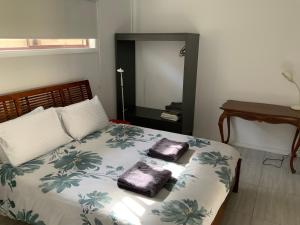 a bedroom with a bed with two towels on it at Jetty Rd Granny Flat in Normanville