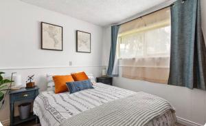 una camera da letto con un letto con cuscini arancioni e blu di Cozy East County Jewel a Portland