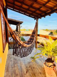 a hammock on a deck with a view of the ocean at Chalés Calica in Caraíva