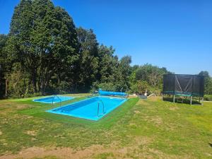 an empty swimming pool in a grassy field at Cabañas alto Volcanes, Puerto Montt in Puerto Montt +24 photos