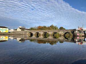 a stone bridge over a body of water at Quiet Riverside Stopover by the Shannon in Leitrim