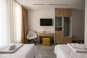 a hotel room with two beds and a desk and a television at Hotel Opal Casa in Novi Pazar