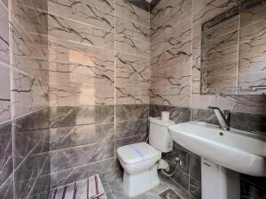 a bathroom with a white toilet and a sink at 129 · 2BR Townhouse 2 Bath TV Backyard in Sheikh Zayed +42 photos