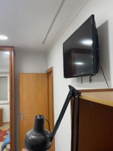 een kamer met een tv op de hoek van een muur bij Casa cidade e piscina in Coimbra