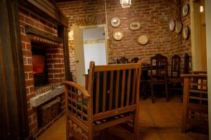 una stanza con un camino in mattoni e una sedia di legno di Quinta das Maçãs by SH ad Alvaiázere