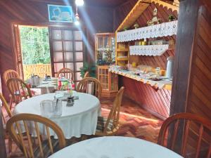 a restaurant with tables and chairs in a room at Cantinho da Deca in São Francisco de Paula