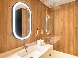 un bagno con lavandino e specchio di Mercure Lyon Est Chaponnay a Chaponnay