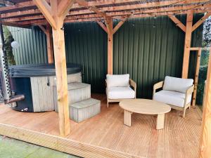 un pergolato con due sedie e un tavolo su una terrazza di Holiday Home de Binnengouw incl Hottub a Hoogwoud Altre 45 foto