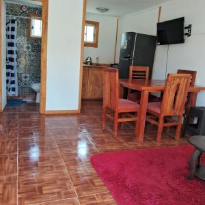 a kitchen with a table and chairs and a refrigerator at Cabañas Montesol Mejor Vista a las estrellas in Choapa