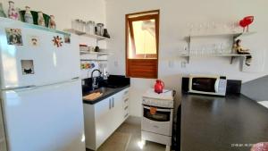 een keuken met een witte koelkast en een spoelbak bij Casa Dendê Praia do Forte in Praia do Forte