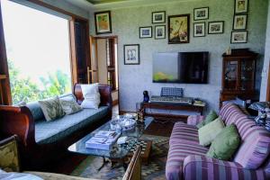 a living room with two couches and a tv at The Chaisai Private Lodge in Ban Huai San Mai