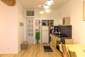 a kitchen with a table and a white refrigerator at Kait location in Pont-sur-Yonne