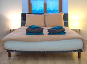 a bed with two towels on top of it at Kait location in Pont-sur-Yonne
