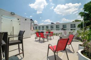 a patio with red chairs and tables on a building at Casa Ama in Mexico City