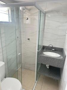 a bathroom with a shower and a sink and a toilet at Suíte Quarto 3km de Florianópolis in São José