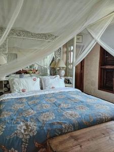 a bedroom with a large bed with a canopy at The Chaisai Private Lodge in Ban Huai San Mai
