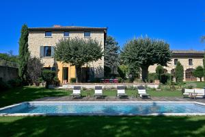 a villa with a swimming pool in front of a house at La Maison et l'Orangerie in Saint-Jean-des-Vignes