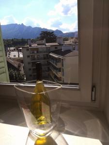 a bottle of wine in a glass on a window sill at Cosy Aix in Aix-les-Bains