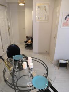 a glass table with blue plates and candles on it at Cosy Aix in Aix-les-Bains