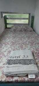 a bed with a blanket on top of it at Hostel33 brazil praia in Caraguatatuba