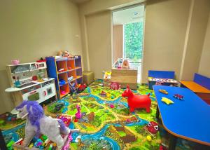 a childs room with a table and toys on the floor at SPA Apartment Alex in Borovets