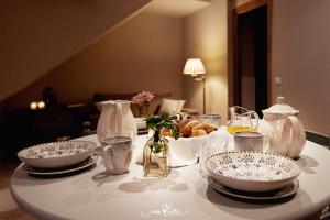 een witte tafel met borden en vazen erop bij Apartamentos Turísticos En un lugar de tu Casa in Villanueva de los Infantes +5 foto's