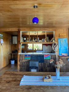 a kitchen with a table with a vase of flowers on it at Hostal Casa Damasco in Ancud