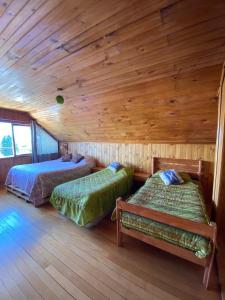 a bedroom with two beds in a log cabin at Hostal Casa Damasco in Ancud +48 photos