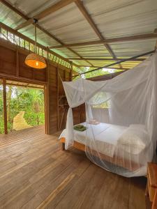 een slaapkamer met een bed met een klamboe bij Madre Selva Eco Lodge in Nuquí