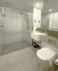 een badkamer met een douche, een toilet en een wastafel bij Aspire Boutique Condo Melbourne CBD in Melbourne