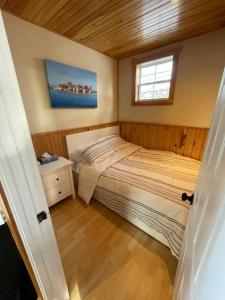 a small bedroom with a bed and a window at The Nook - Sherbrooke Cottages in Summerside